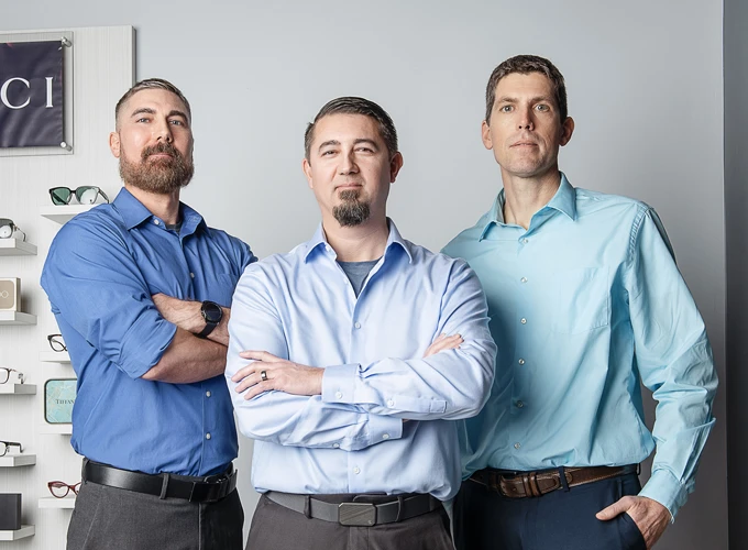 Drs. Bill Sullivan O.D., J.C. Sullivan O.D., and Adam D. Good O.D. posing in the clinic lobby