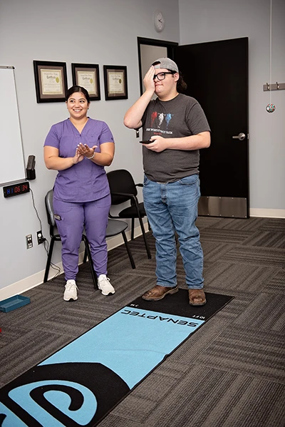 Eye Doctor Pasco WA Teenager Vision Therapy A young man supervised by an eye care practitioner covering one eye during a vision test